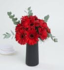 Red Gerbera Flowers in a Black Striped Vase