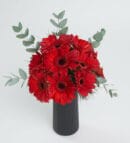 Red Gerbera Flowers in a Black Striped Vase